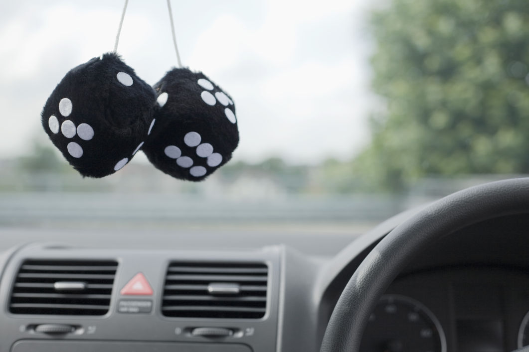 It is illegal to hang "obstructions" from the rear view mirror, including fuzzy dice, air fresheners, GPS units, etc.